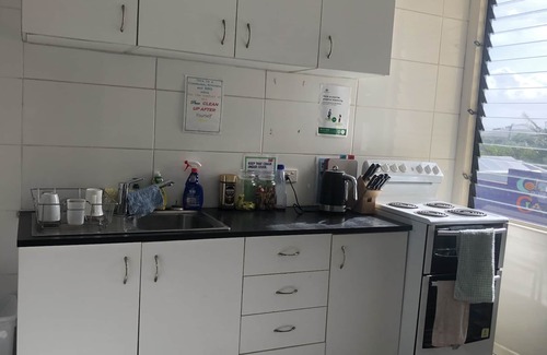 Proserpine Apartment | Clean tidy hotel room with a shared kitchen and shower area