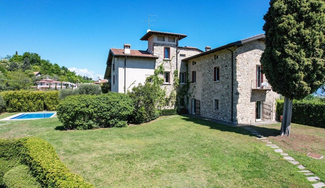 Luxurious villa surrounded by greenery with swimming pool and lake view